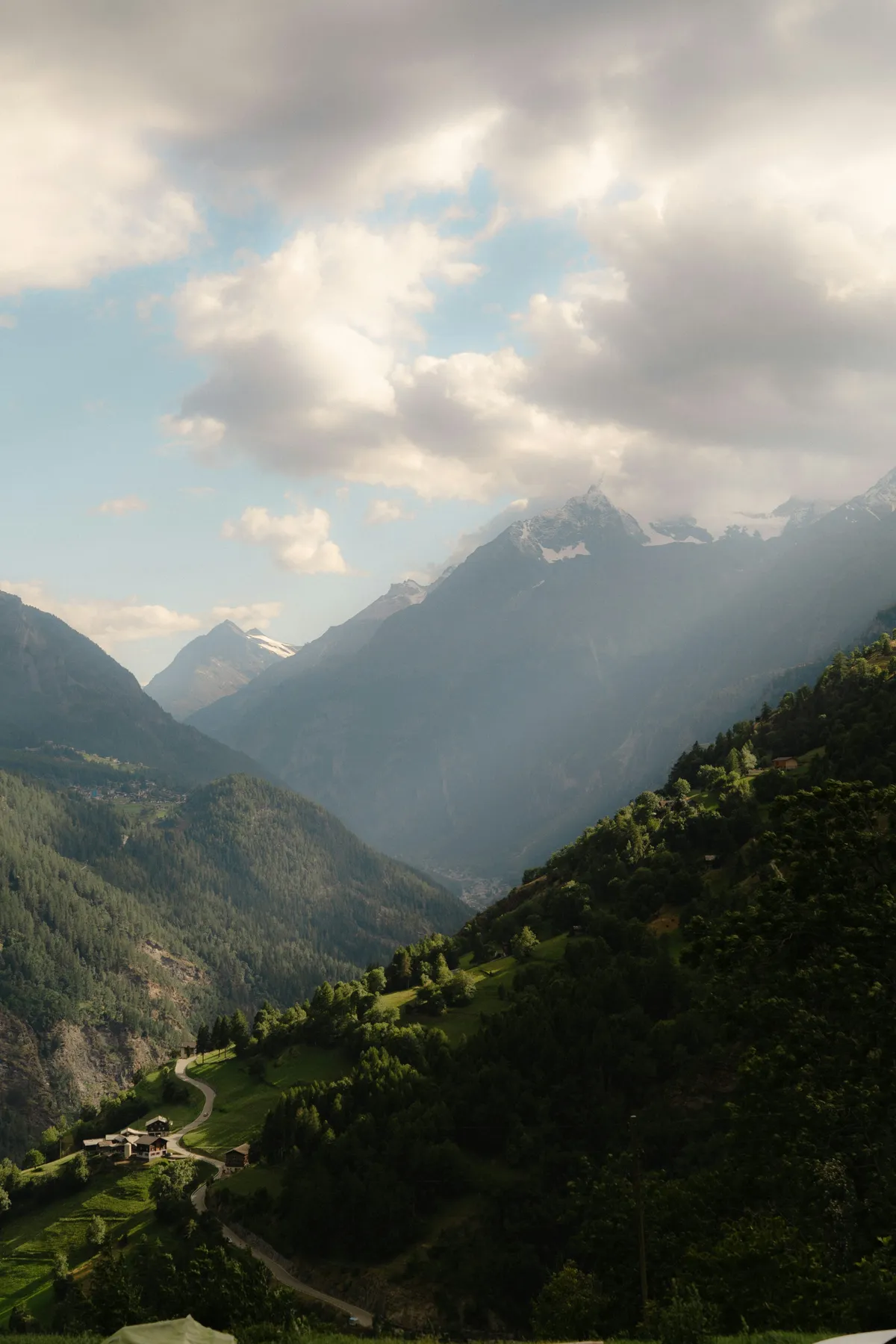 Sunlight breaking through cloud over a forested Himalayan valley